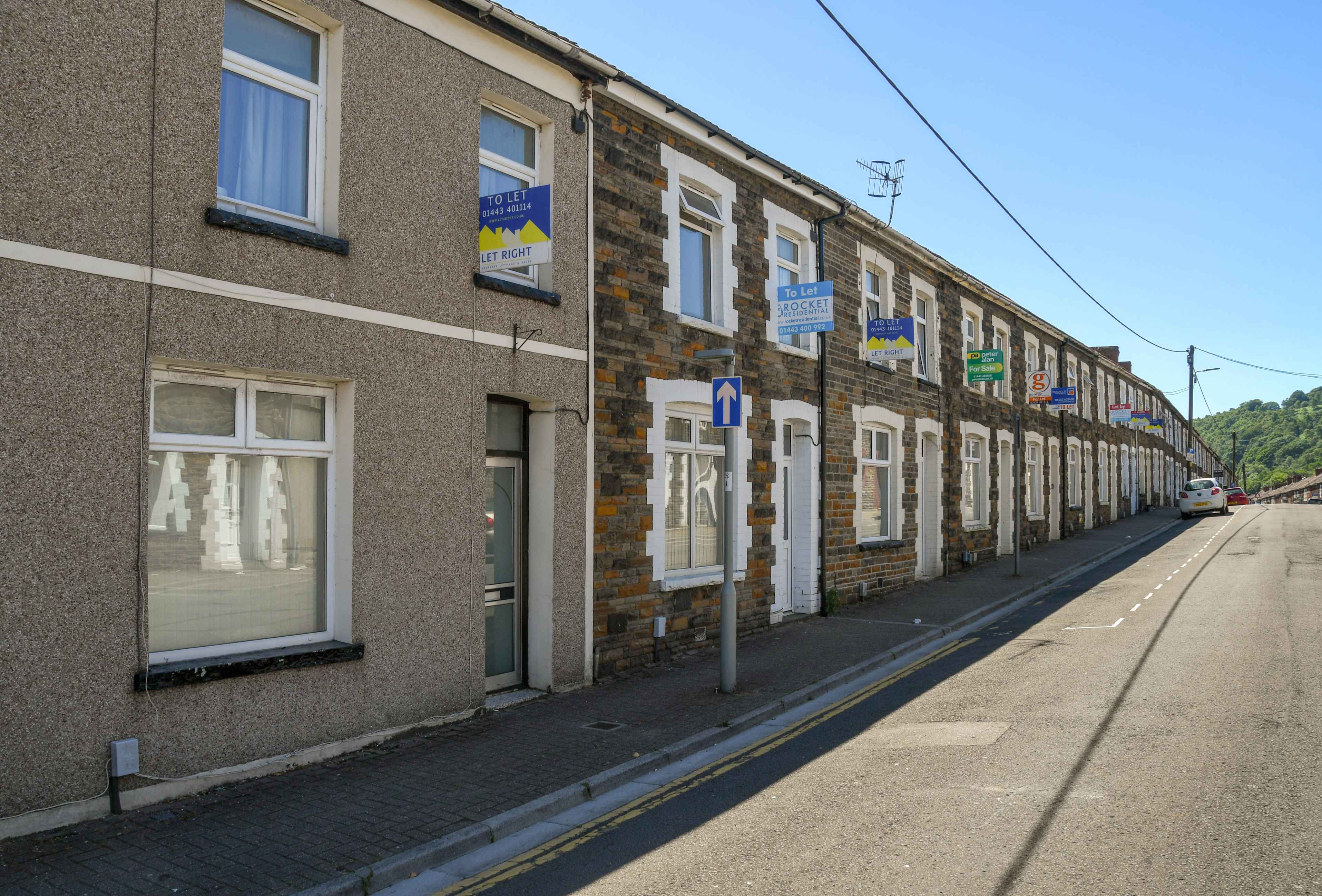 A terraced row of South Wales valleys houses showing ‘to let’ signs.